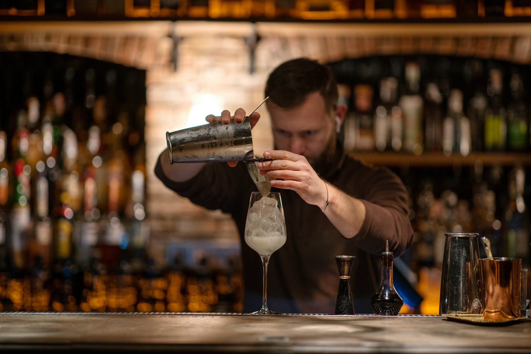 Bartender making a cocktail behind a bar